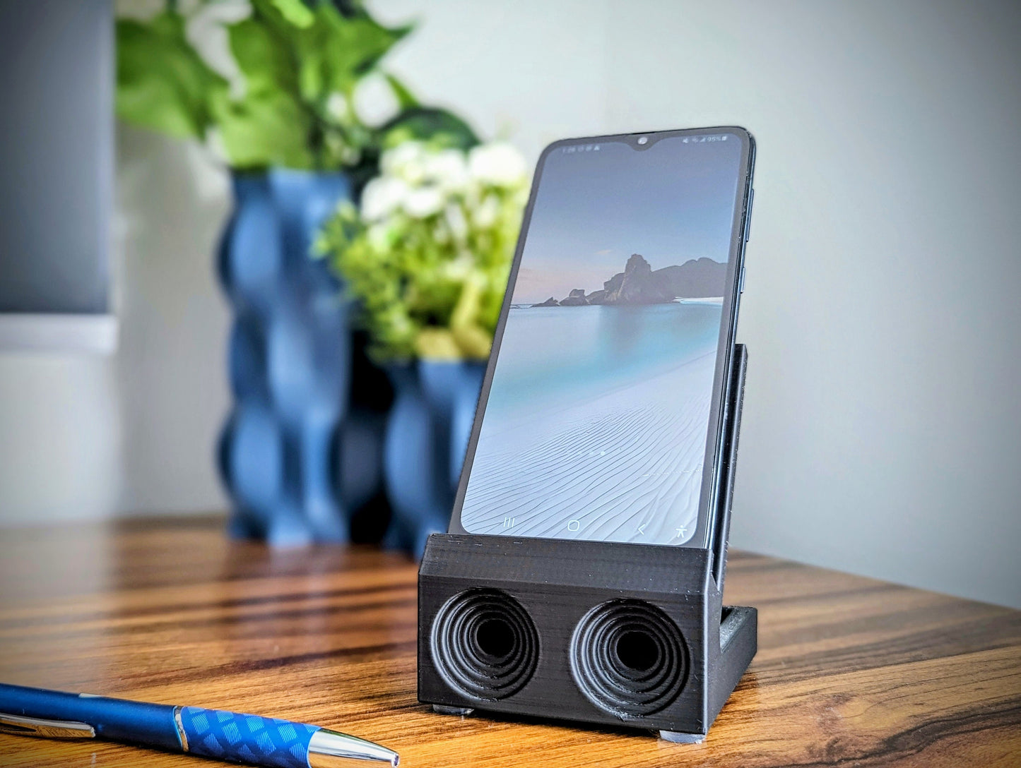 Phone stand with acoustic booster. Back tray ideal for storing air pods or earbuds. Comes in a variety of colors and may be customized for the dimensions of any device.