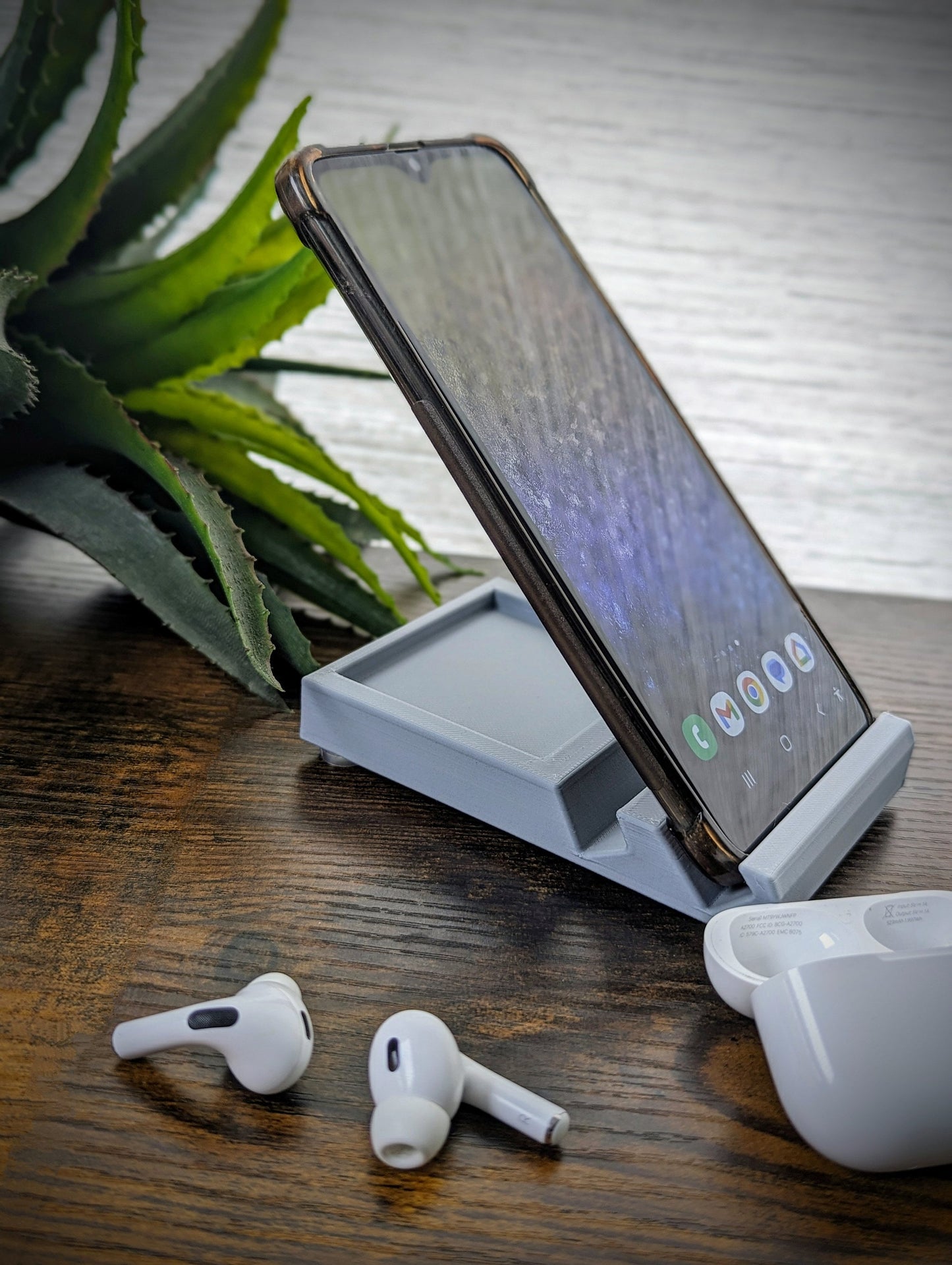 Minimalist phone holder with two display vantage angles. Back tray ideal for storing air pods or earbuds. Comes in a variety of colors and may be customized for the dimensions of any device.