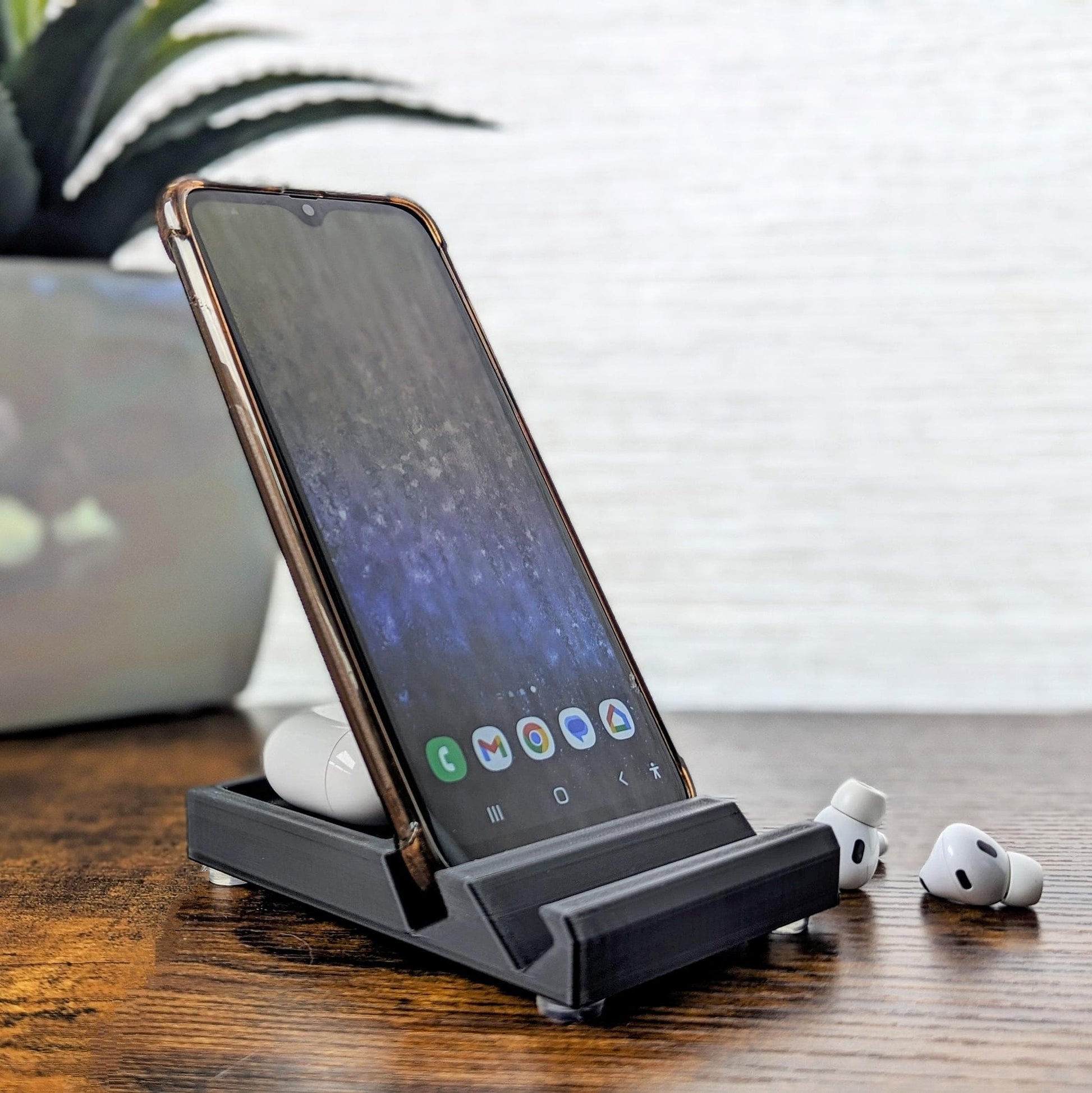 Minimalist phone holder with two display vantage angles. Back tray ideal for storing air pods or earbuds. Comes in a variety of colors and may be customized for the dimensions of any device.