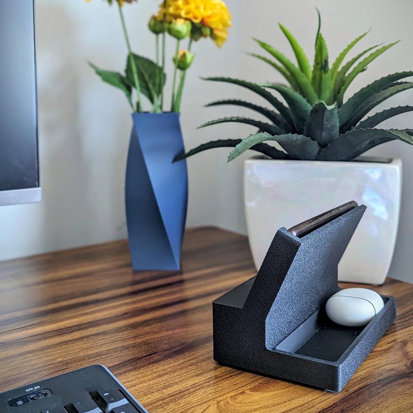 Phone stand with acoustic booster ideal for movie viewing. Back tray ideal for storing air pods or earbuds. Comes in a variety of colors and compatible with nearly all phones.