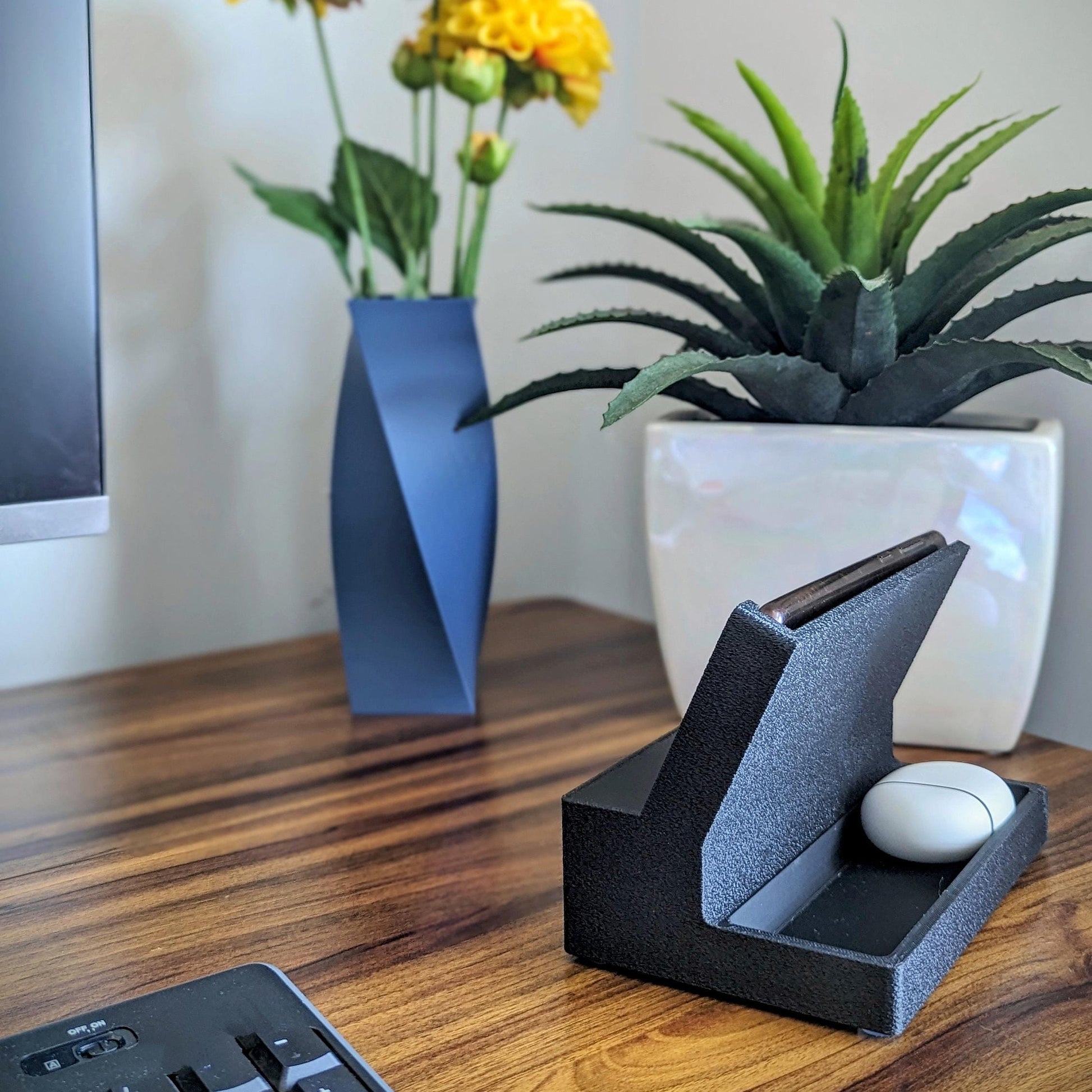 Phone stand with acoustic booster ideal for movie viewing. Back tray ideal for storing air pods or earbuds. Comes in a variety of colors and compatible with nearly all phones.