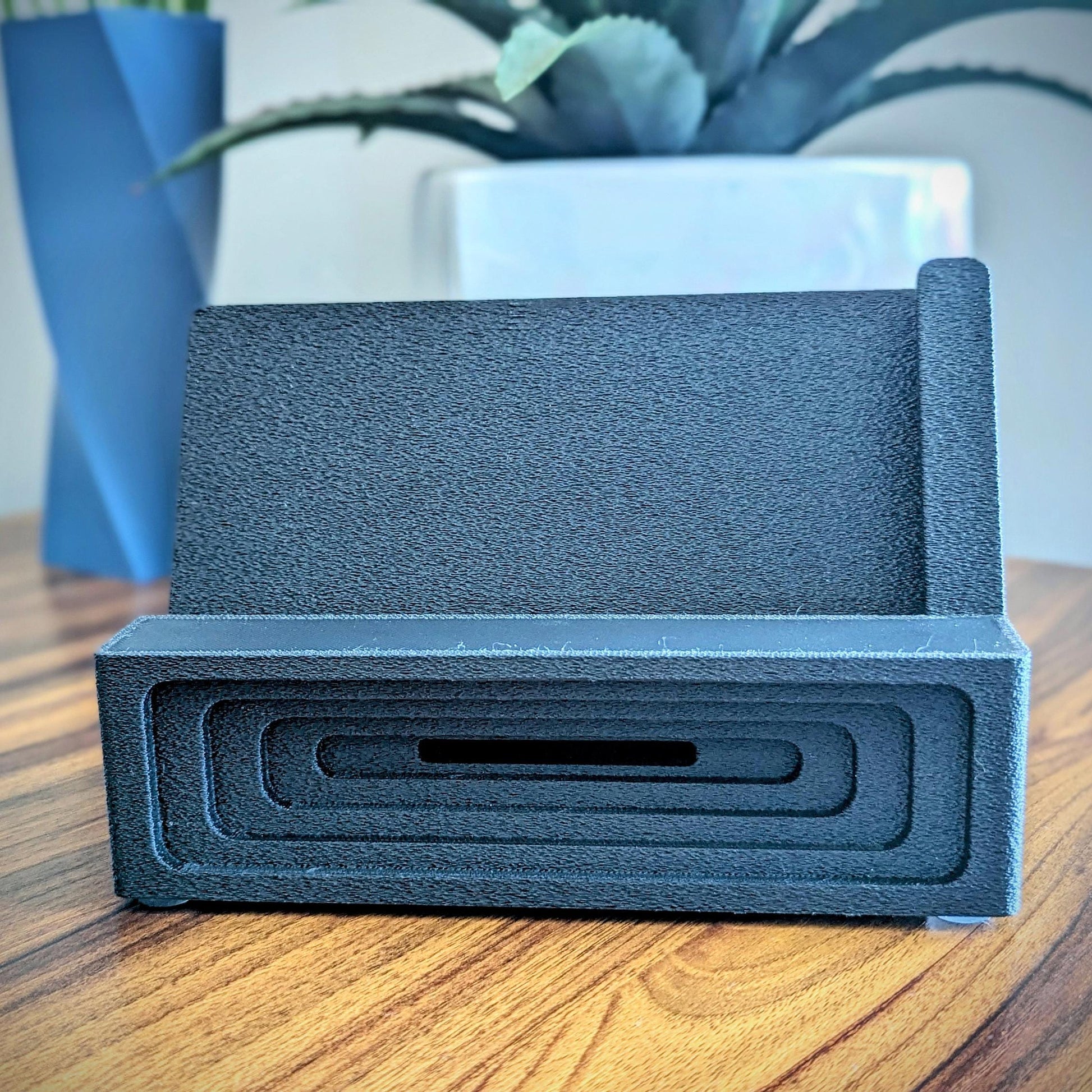 Phone stand with acoustic booster ideal for movie viewing. Back tray ideal for storing air pods or earbuds. Comes in a variety of colors and compatible with nearly all phones.